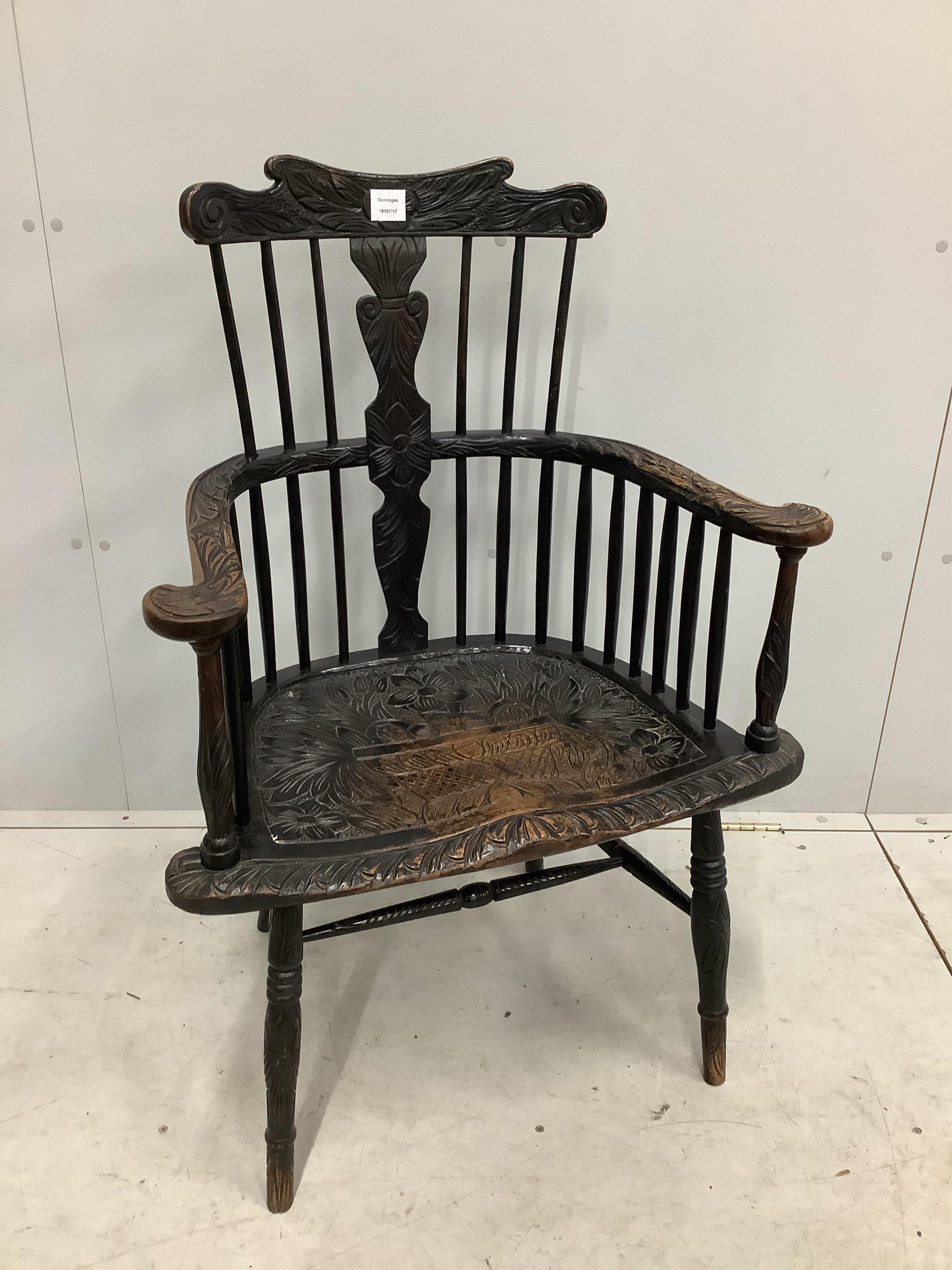 A 19th century Windsor comb back elbow chair, later stained and carved, width 69cm, depth 45cm, height 101cm. Condition - fair to good